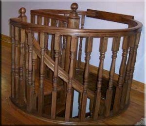 A wooden spiral staircase with a wooden railing