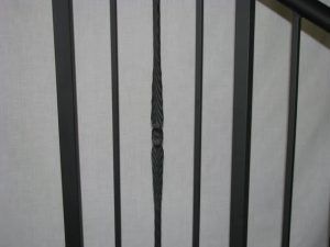 A close up of a black metal railing on a staircase.