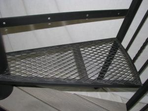 A close up of a metal staircase with a mesh bottom