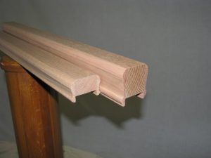 A wooden railing is sitting on top of a wooden post.