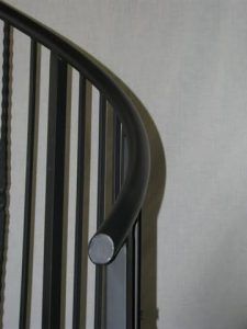 A close up of a metal railing on a spiral staircase.