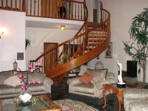 A living room with a spiral staircase leading to the second floor