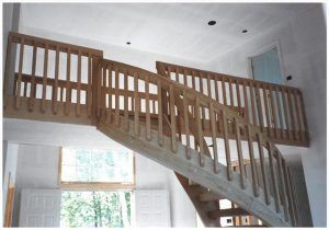 A wooden staircase with a railing in a house