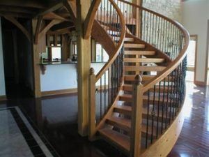 A wooden spiral staircase with metal railing in a house