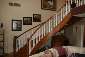 A living room with a wooden staircase and white railings
