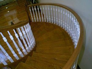 A spiral staircase with wooden steps and white railings