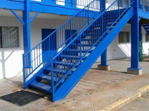 A blue staircase is outside of a building