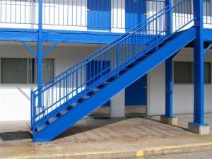 A blue staircase is outside of a building