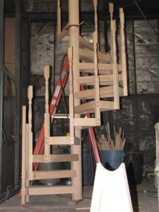 A wooden spiral staircase with a ladder on top of it