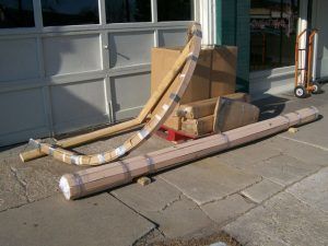 A bunch of boxes are sitting on the sidewalk in front of a garage door.