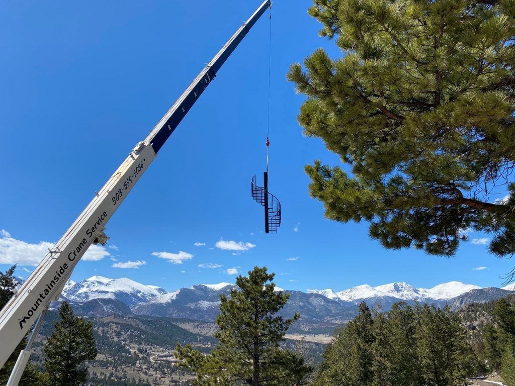 A crane is hanging from a tree in the mountains.