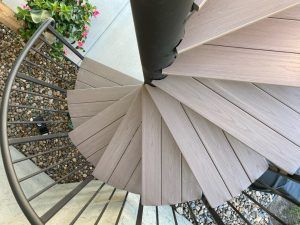 A spiral staircase with wooden steps and a metal railing
