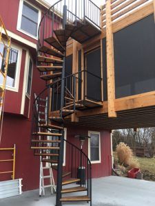 A spiral staircase is going up to the second floor of a house.