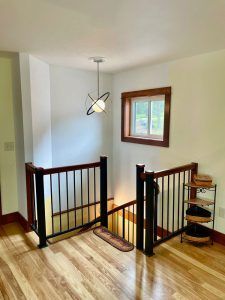 A staircase with a wooden railing and a window in a house.