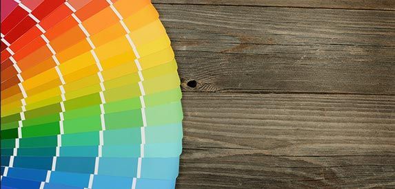 A rainbow of colors is on a wooden table.