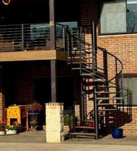 A brick building with a spiral staircase leading up to the second floor.
