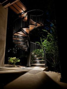 A spiral staircase is lit up at night.