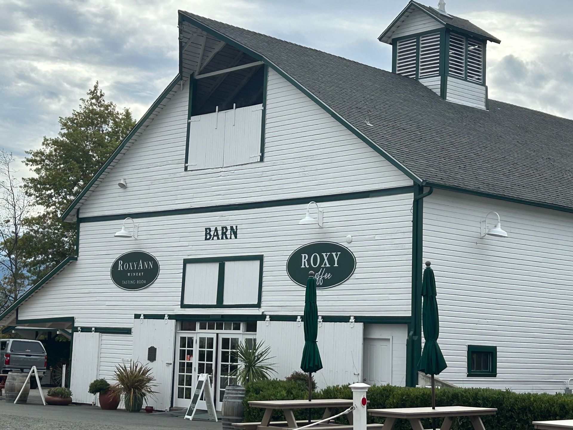 White barn with green trim, signage 