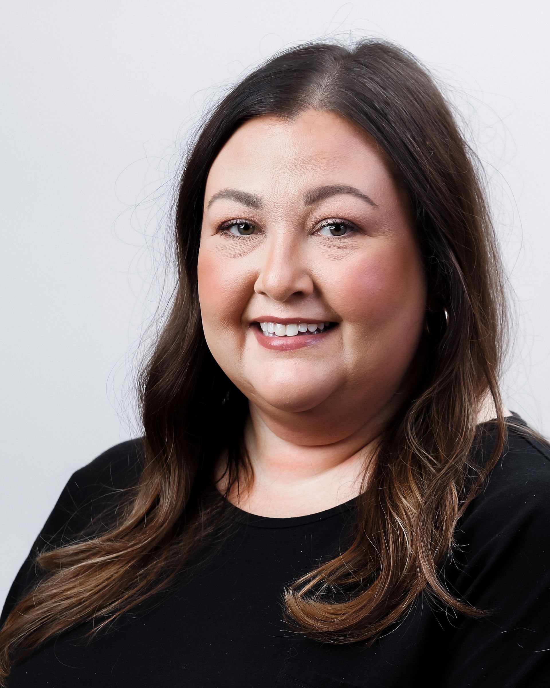 A woman in a black shirt is smiling for the camera.