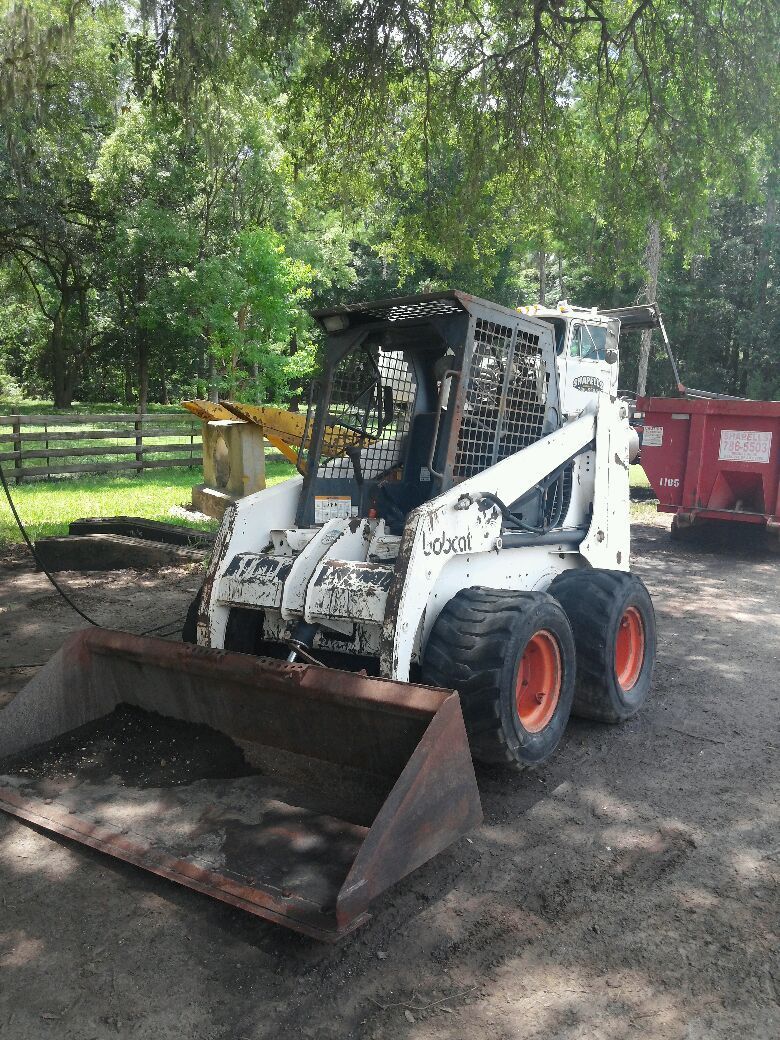 A bobcat skid steer is parked in a dirt lot.