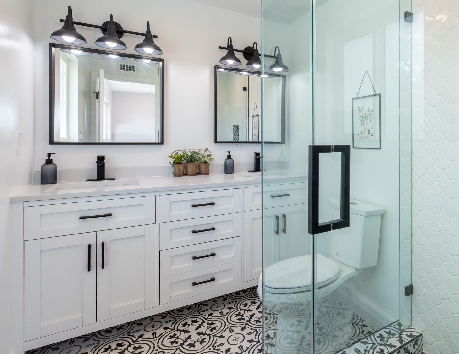 a bathroom with two sinks , a toilet , and a walk in shower .