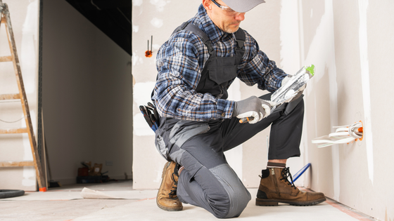 Unfinished basement with wooden framework, concrete floor, windows, and exposed ceiling beams.