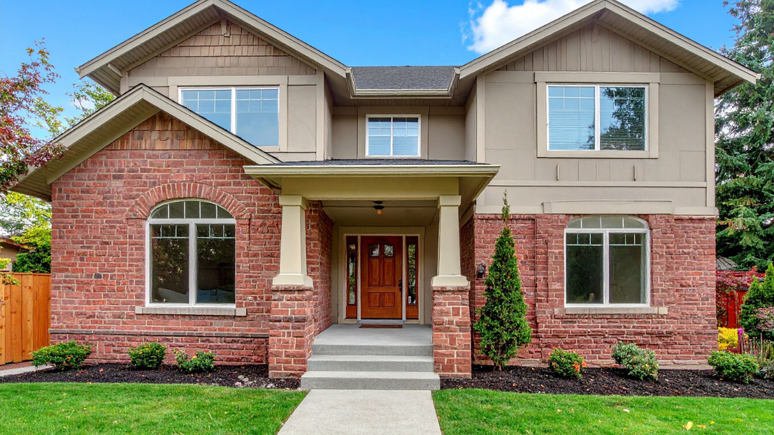 Construction worker leveling roof rafters with a yellow level. Bright sunlight.
