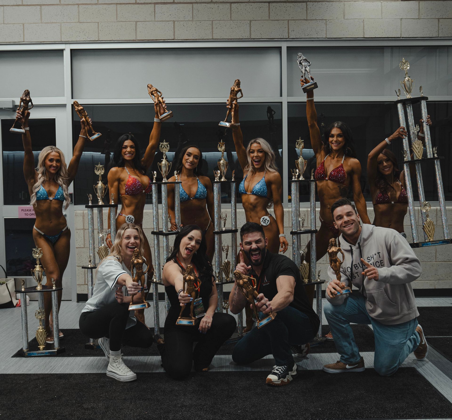 A group of people posing for a picture holding trophies