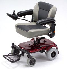 A maroon and grey motorized wheelchair with joystick controller, armrests, and footrest on a white background.