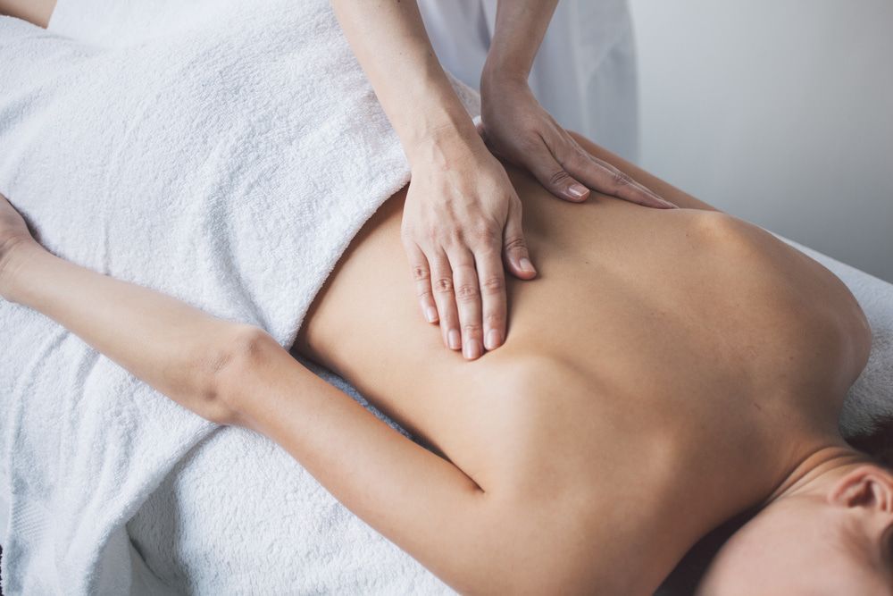 A Woman Is Getting A Massage On Her Back In A Spa — A Myo-Therapy Approach To Remedial & Bowen Therapies In West Gladstone, QLD