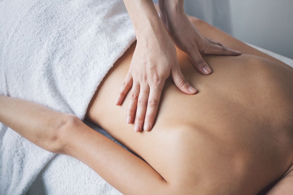 A Woman Is Getting A Massage On Her Back In A Spa — A Myo-Therapy Approach To Remedial & Bowen Therapies In West Gladstone, QLD