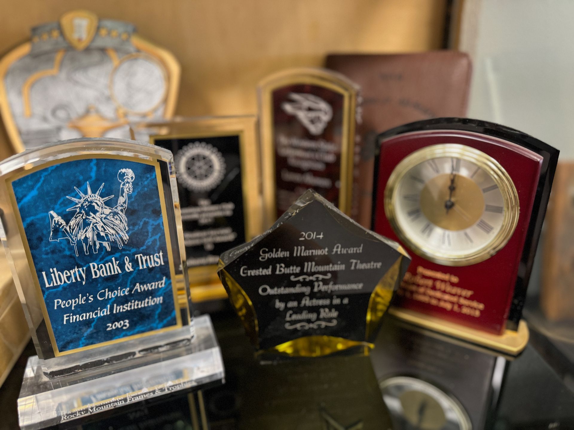 A group of trophies and a clock on a table.