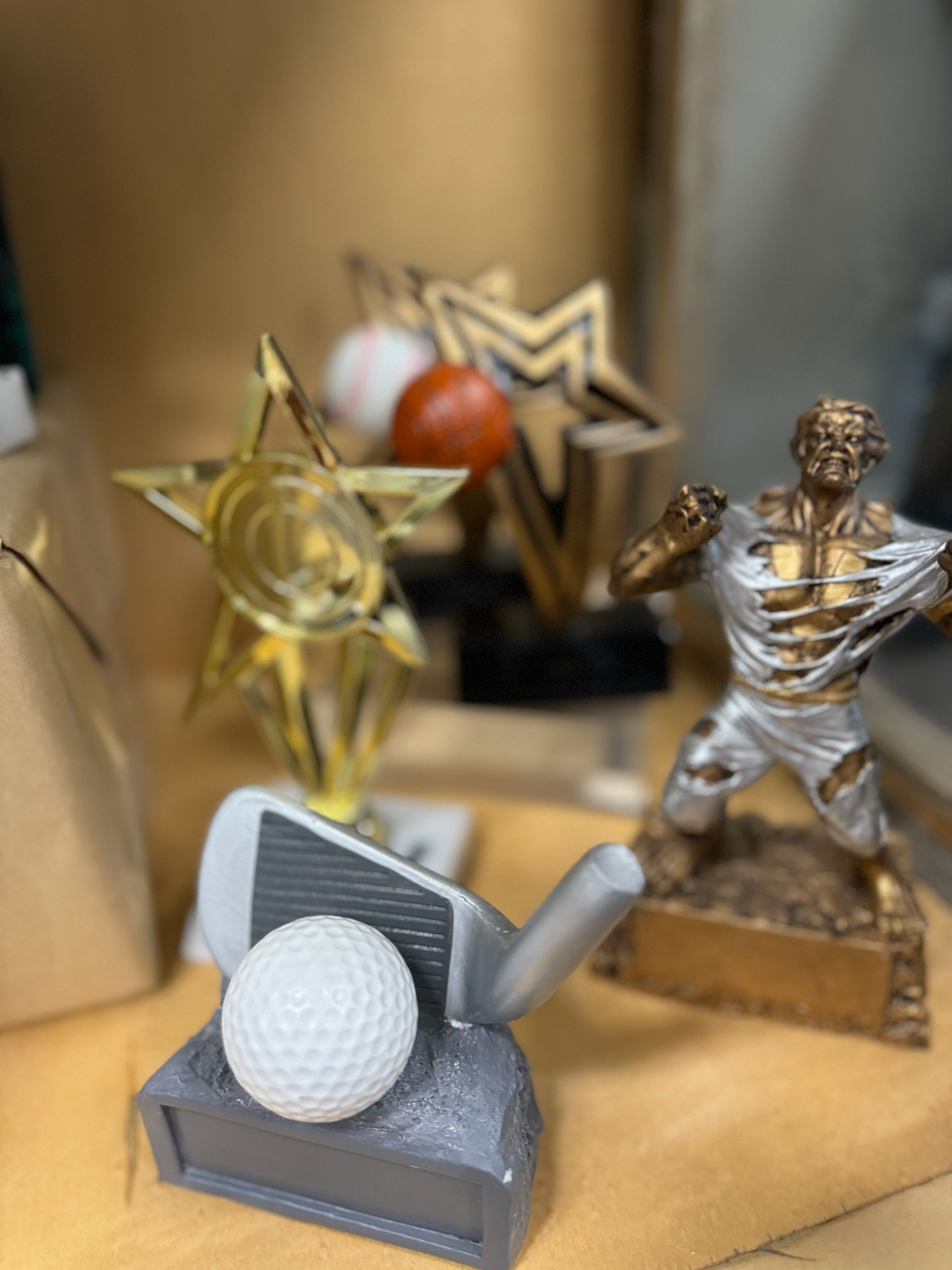 Several trophies are on a table including a golf ball