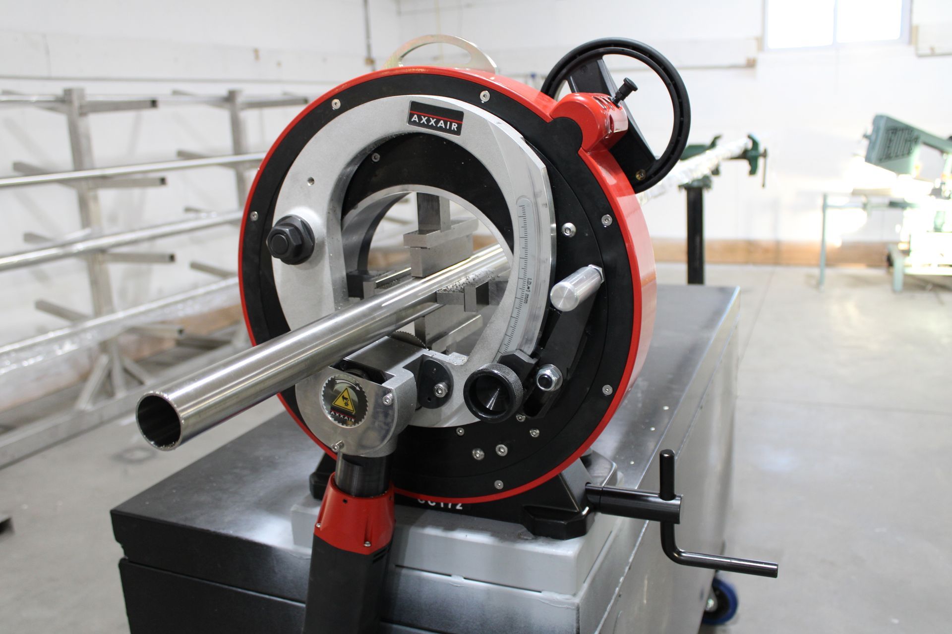 A machine is cutting a metal pipe in a factory.