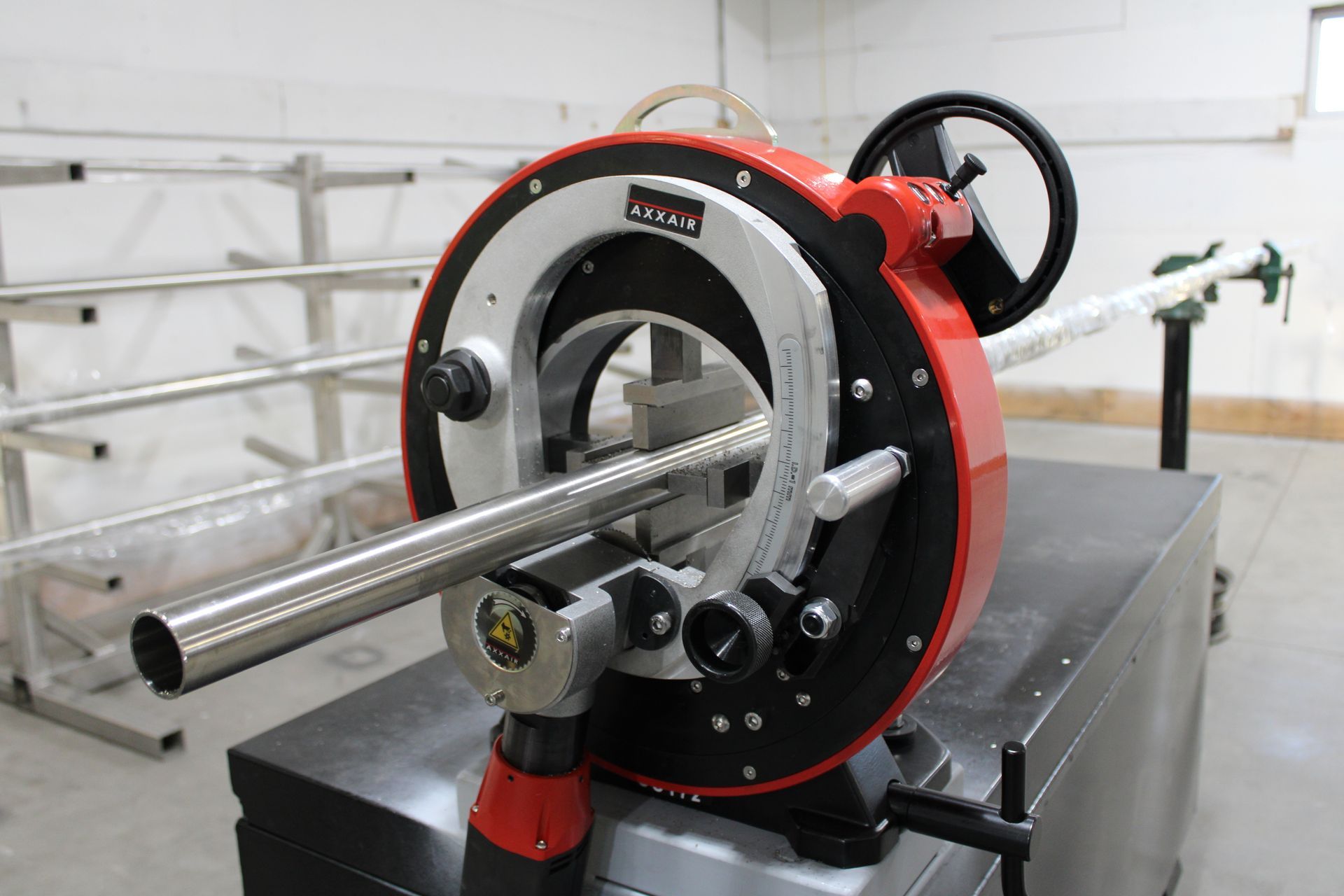 A machine is cutting a metal pipe in a room.
