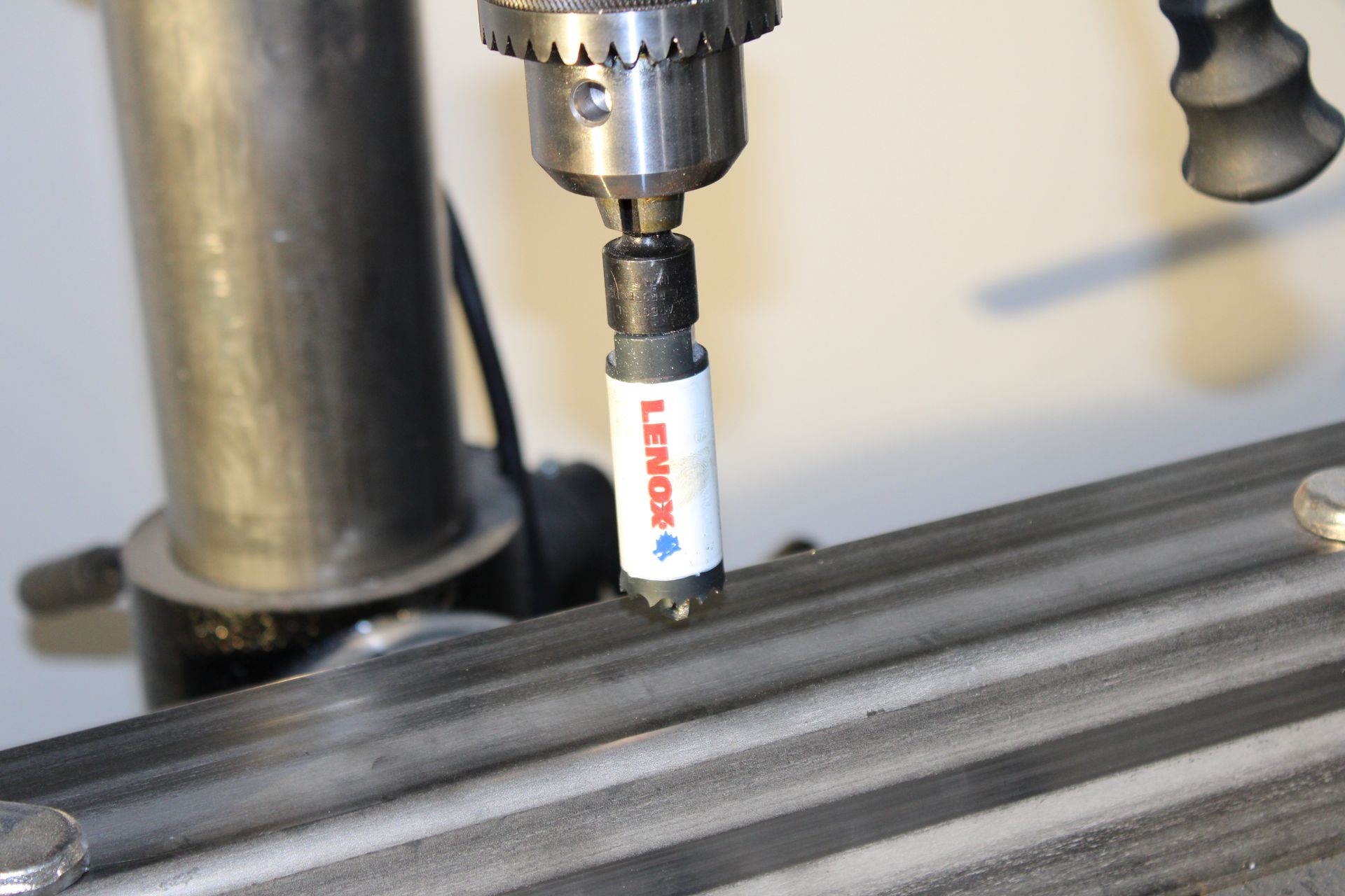 A drill bit is being used to drill a hole in a piece of metal.