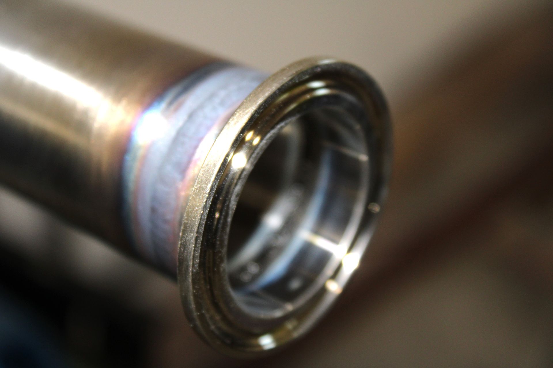 A close up of a metal pipe with a flange on it