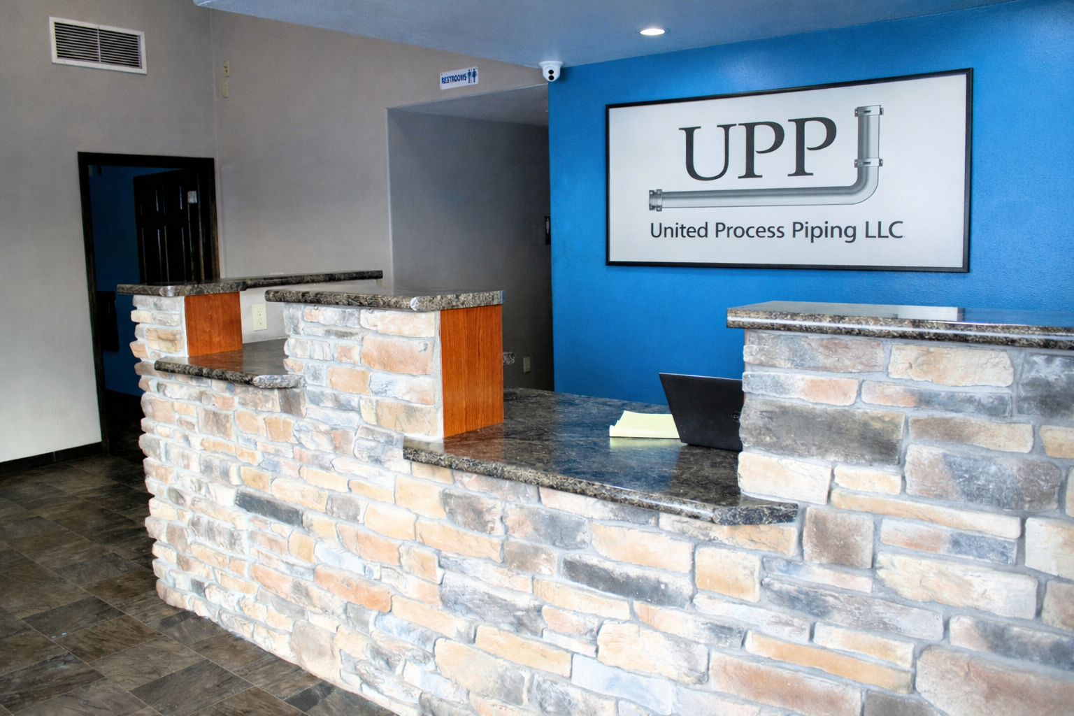 Two red trucks are parked in front of a white building.