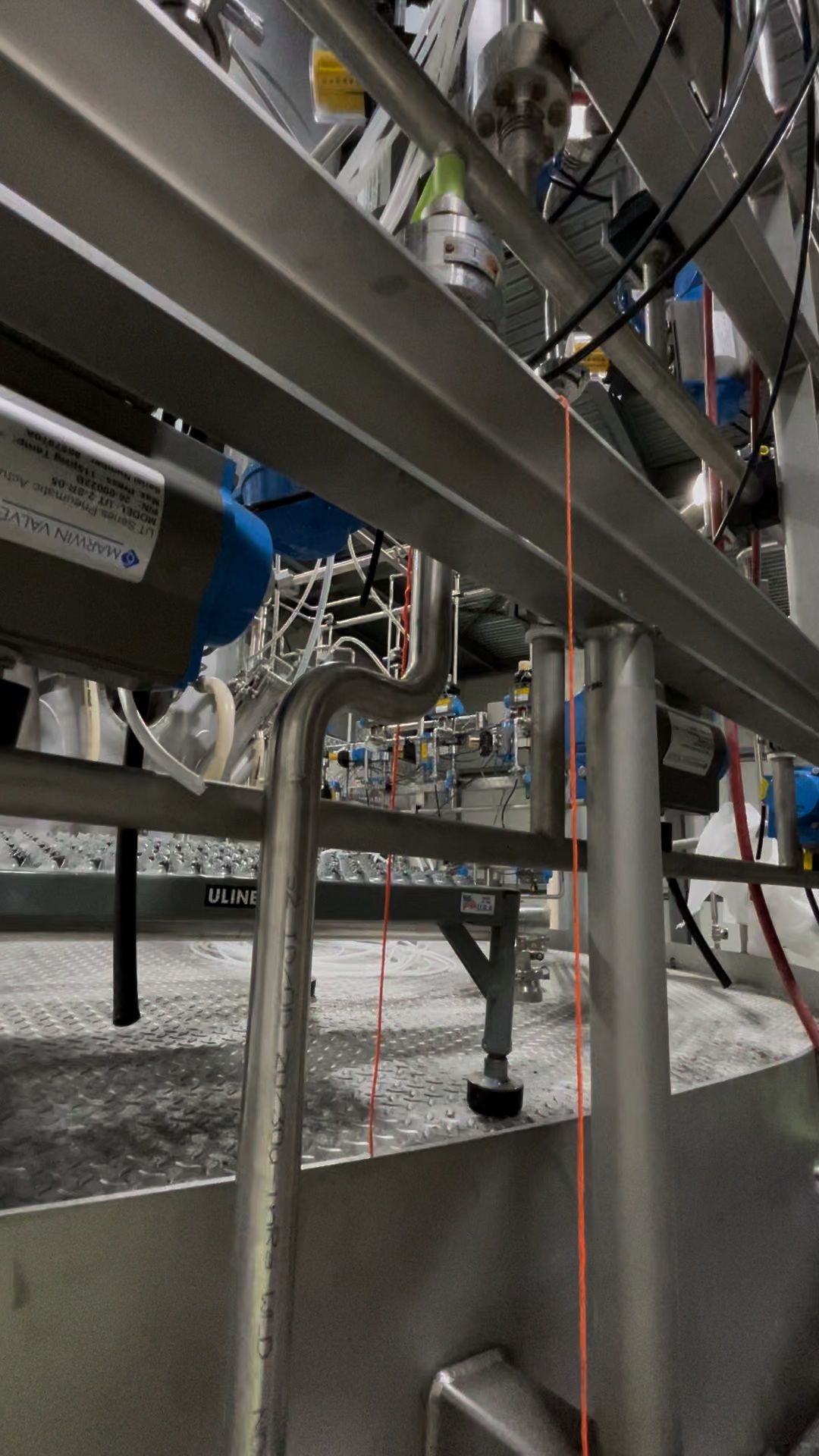 A close up of a stainless steel pipe in a factory.
