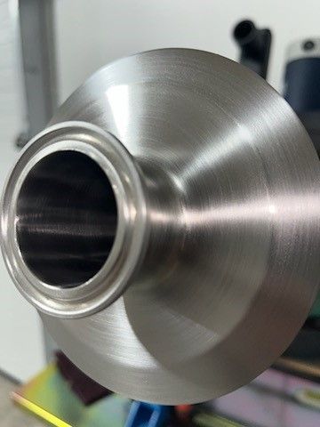 A close up of a stainless steel object with a hole in the middle.