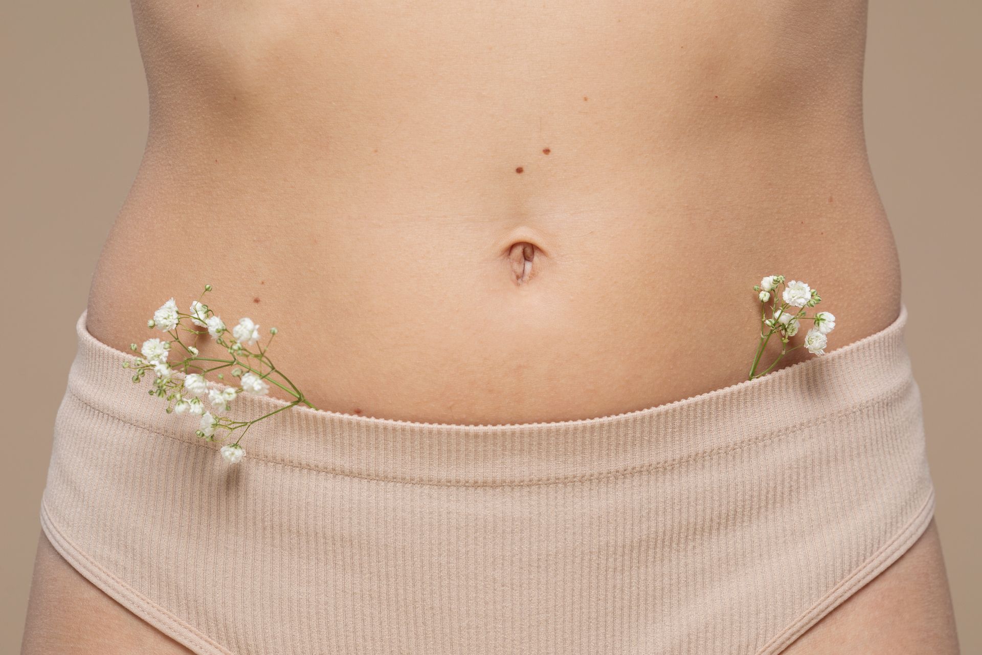 a close up of a woman 's stomach with flowers on it