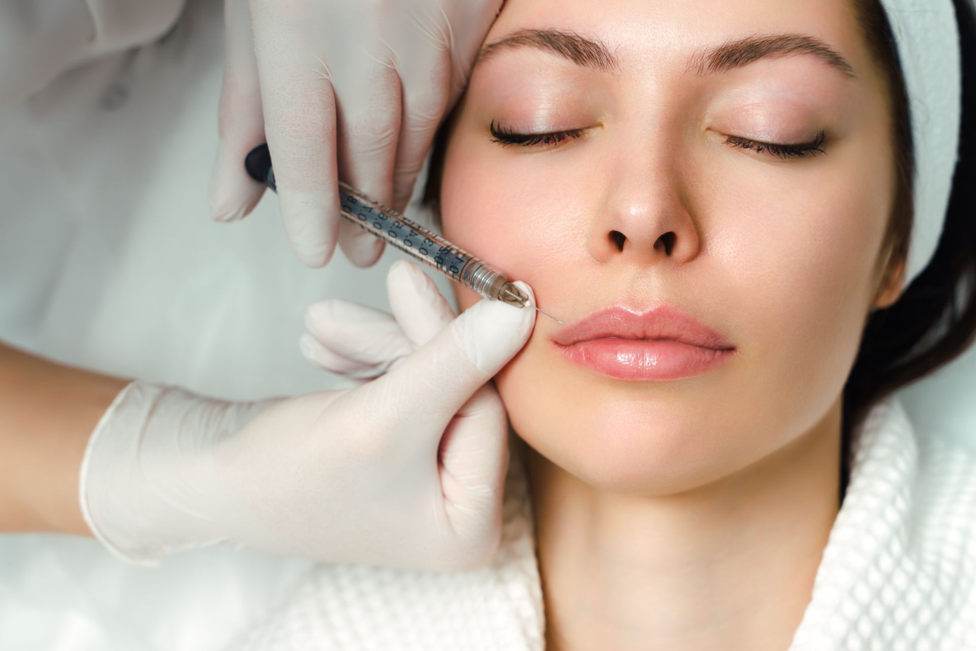 a woman is getting a botox injection in her lip