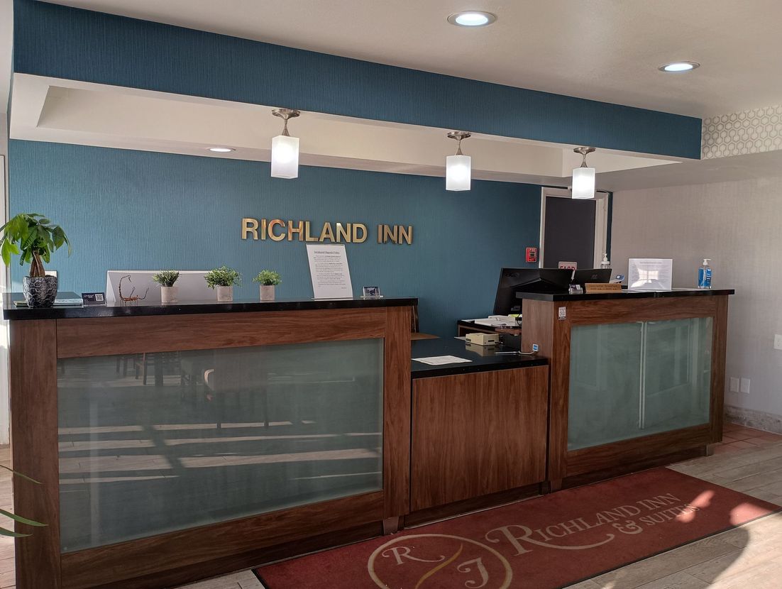 A hotel lobby with a reception desk and a sign that says richland inn.