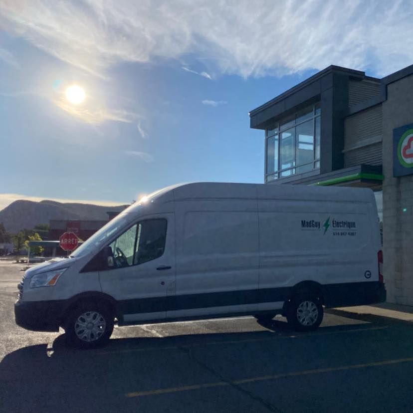 Une camionnette blanche est garée devant un bâtiment sur lequel est écrit Eagle Express
