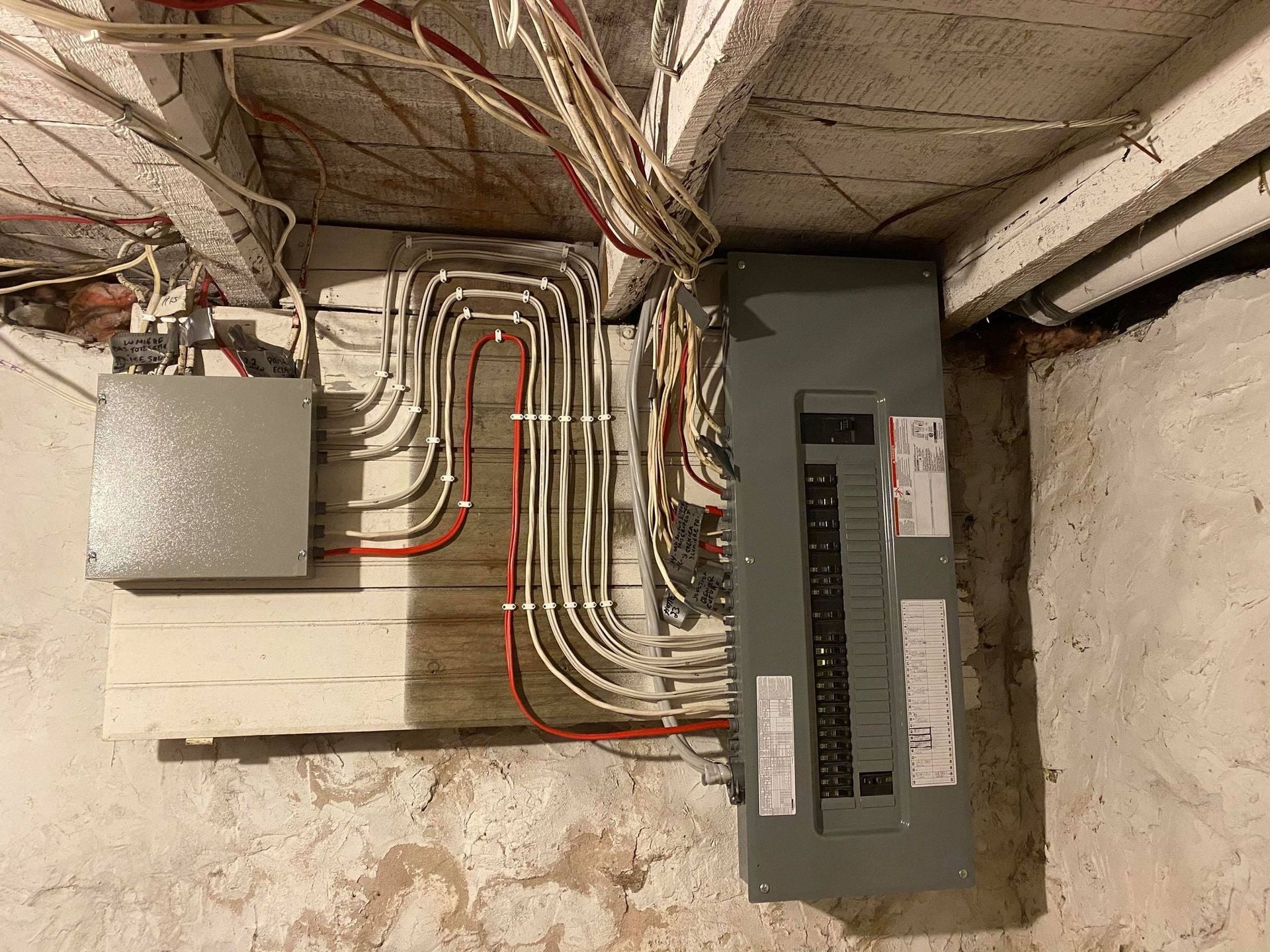 Une boîte électrique est accrochée à un mur dans un sous-sol.