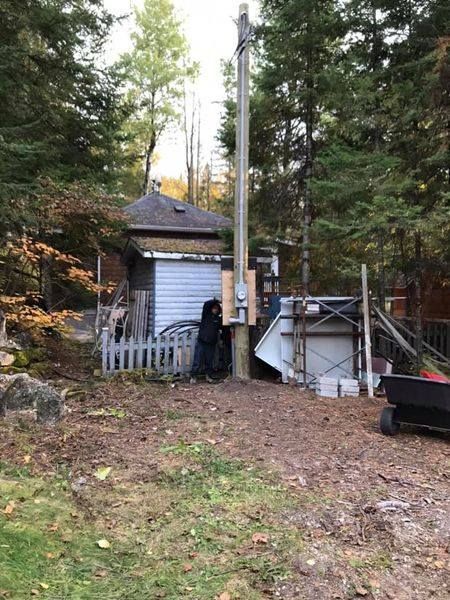 Un homme se tient à côté d'un poteau dans une cour.