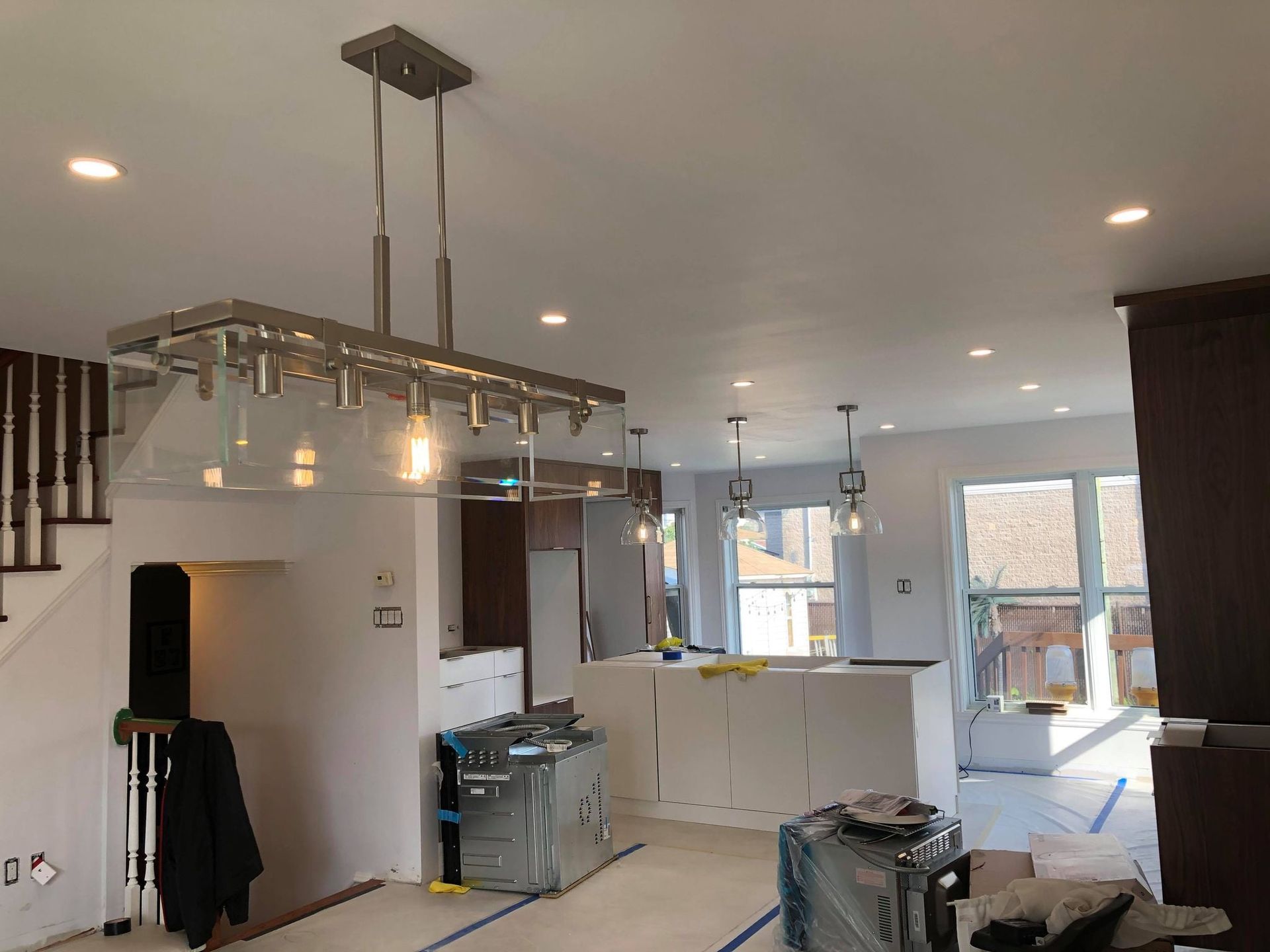 Une cuisine en construction avec un lustre suspendu au plafond.