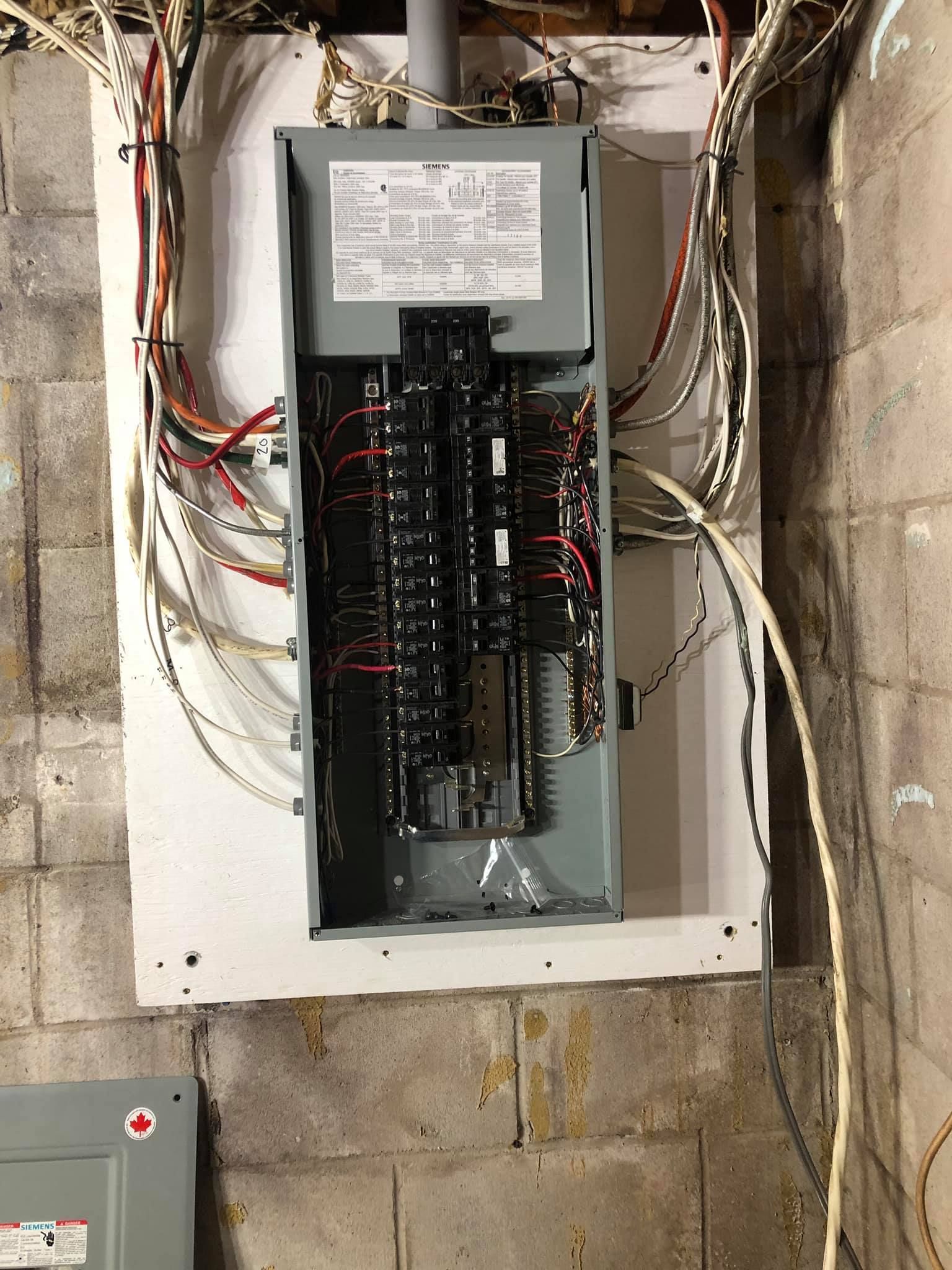 Un boîtier électrique est accroché à un mur de briques.