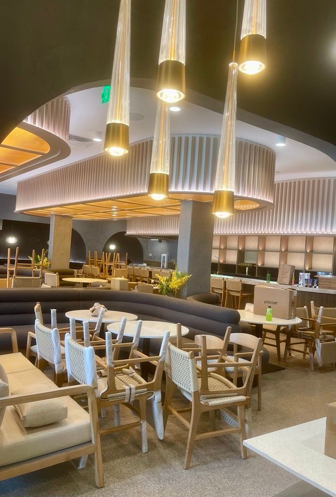 Restaurant interior with tables, chairs, and hanging lights.