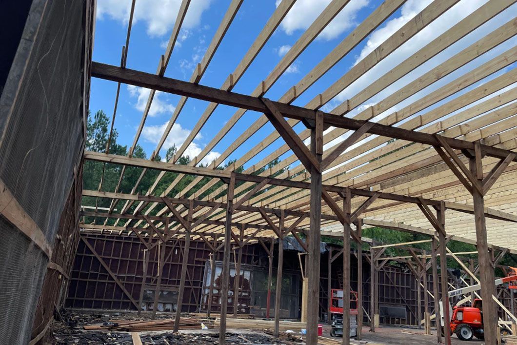 A large wooden structure is being built with a blue sky in the background.